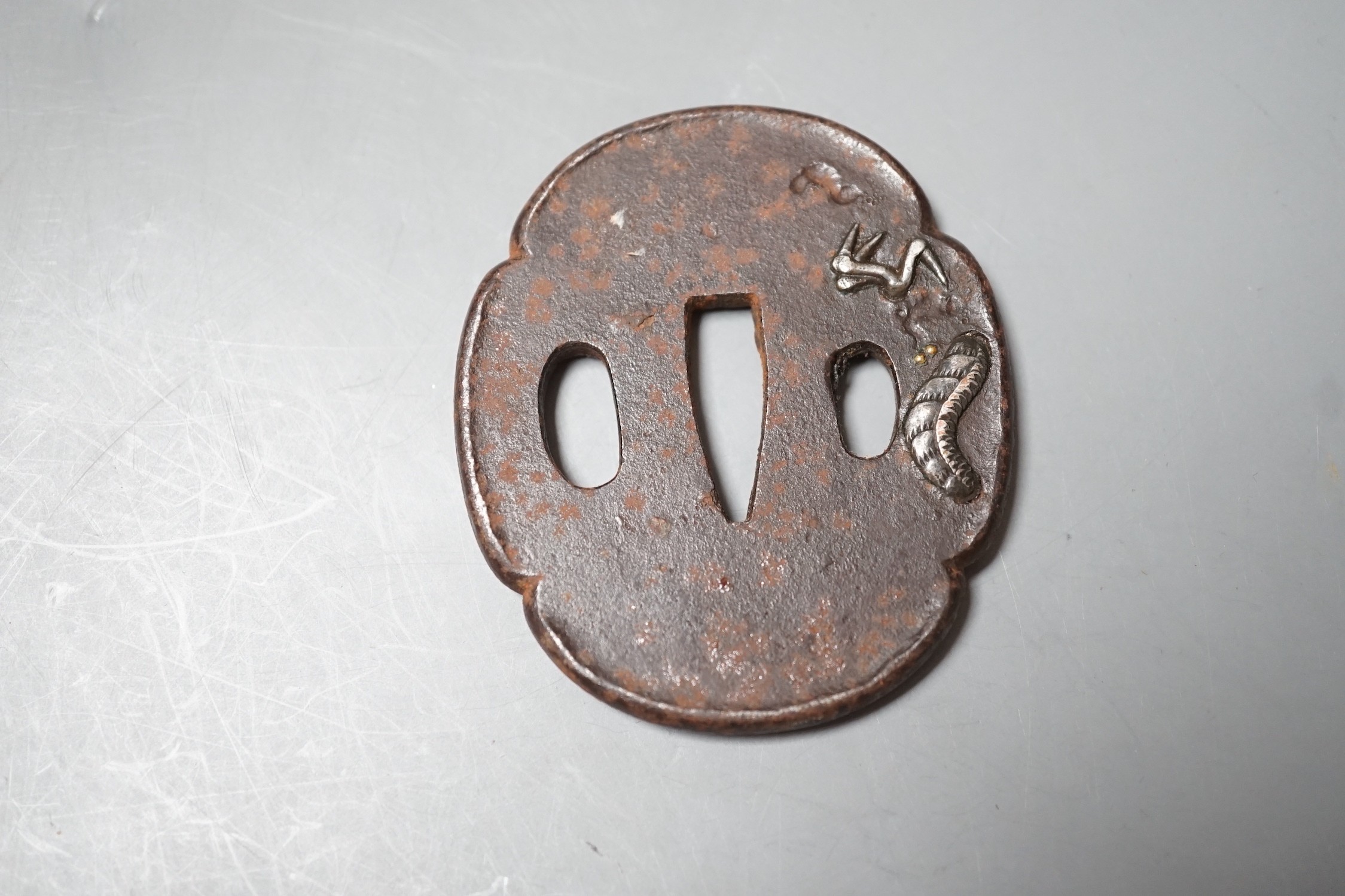 A Japanese Meiji silver and gold overlaid iron tsuba, 6.5cm high